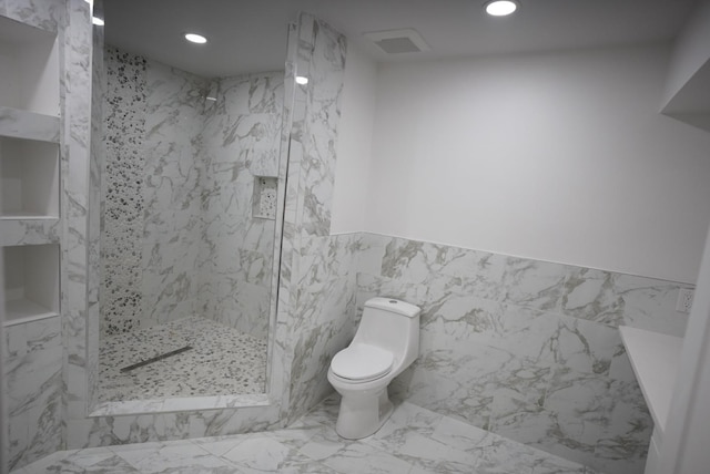 bathroom featuring recessed lighting, marble finish floor, toilet, a walk in shower, and tile walls
