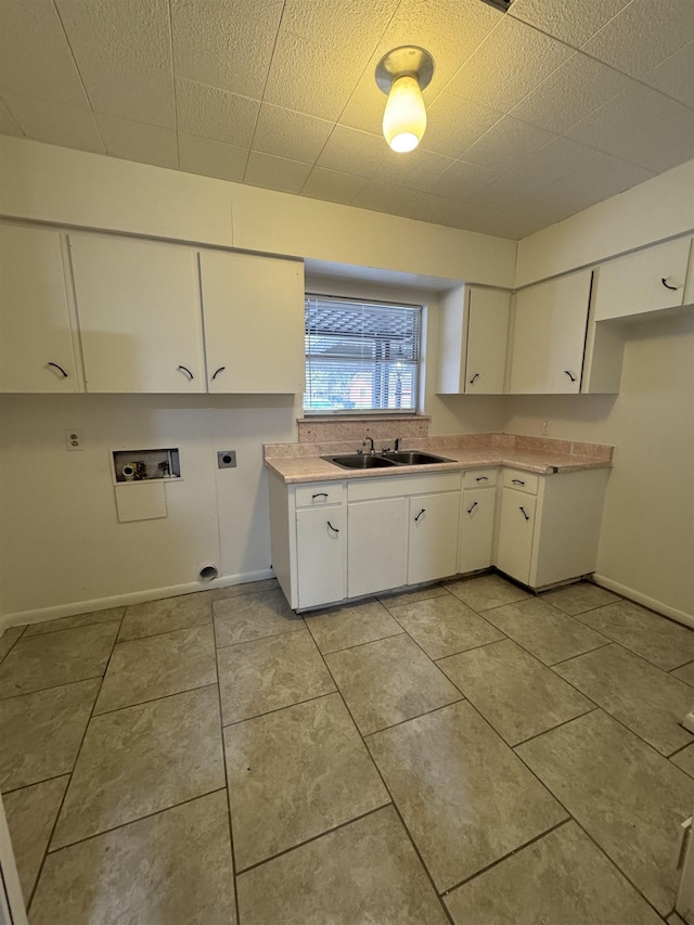 kitchen with light tile patterned flooring, sink, and white cabinetry