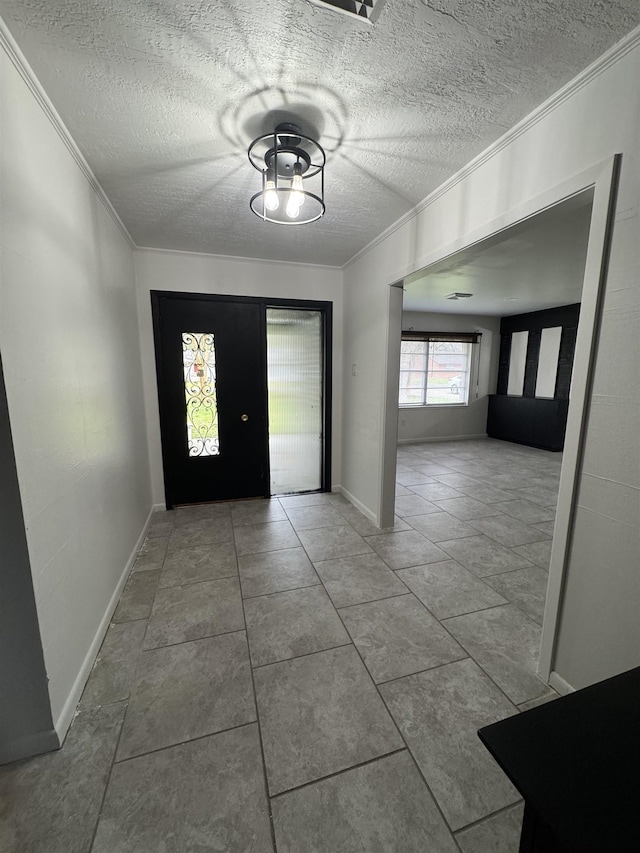 tiled foyer with a textured ceiling and ornamental molding