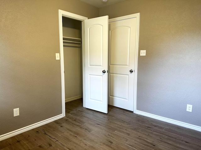 7165 Lewis Dr, Beaumont, TX 77708 - unfurnished bedroom with baseboards, dark wood-style flooring, and a closet