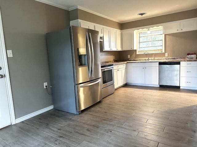 7165 Lewis Dr, Beaumont, TX 77708 - kitchen with stainless steel appliances, ornamental molding, white cabinets, a sink, and wood finished floors