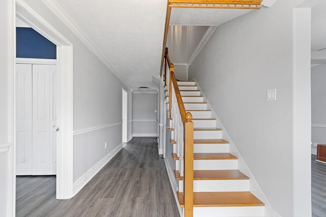 stairs with hardwood / wood-style floors and crown molding