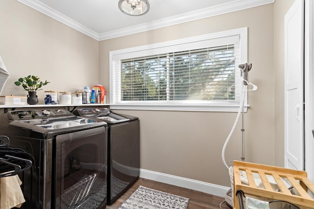 laundry room with wood-type flooring, washing machine and dryer, and crown molding