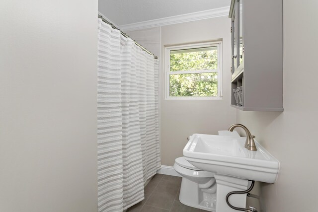 bathroom featuring tile patterned floors, toilet, and crown molding