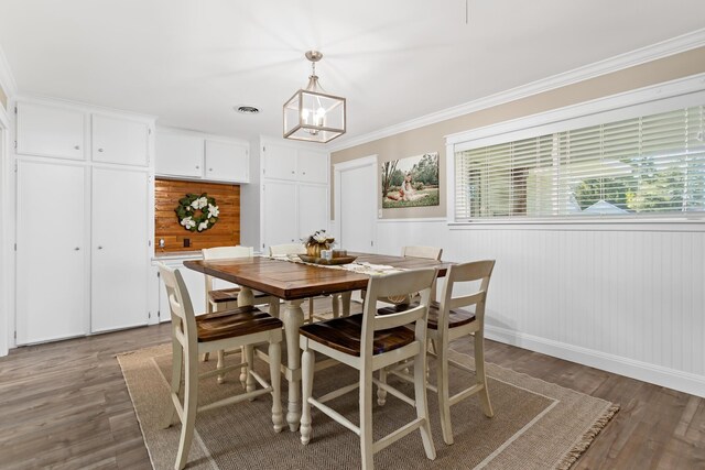 dining space with a chandelier, dark hardwood / wood-style flooring, and crown molding