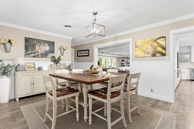 dining room featuring hardwood / wood-style floors, a notable chandelier, and crown molding