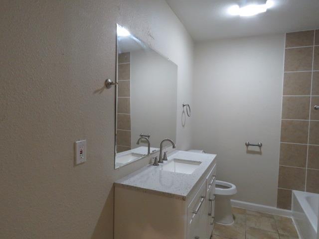 800 Cactus St, Bridge City, TX 77611 - bathroom with vanity, shower / bathtub combination, and tile patterned floors
