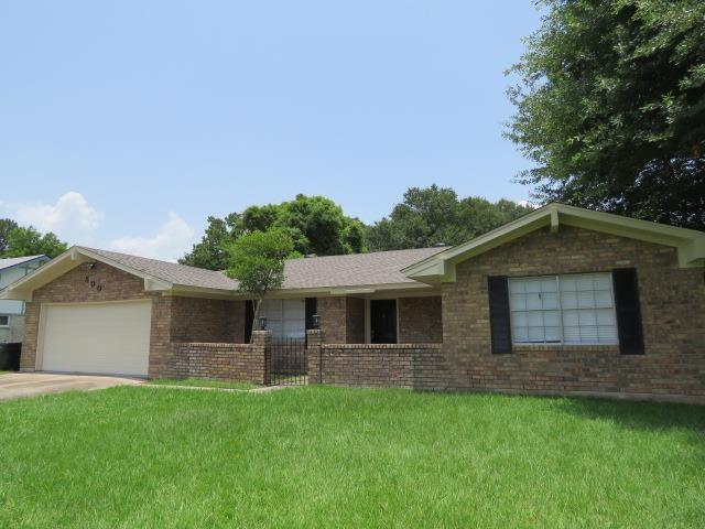 800 Cactus St, Bridge City, TX 77611 - ranch-style home with a garage, a front lawn, concrete driveway, and brick siding
