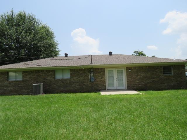 800 Cactus St, Bridge City, TX 77611 - back of house featuring french doors, a yard, and brick siding
