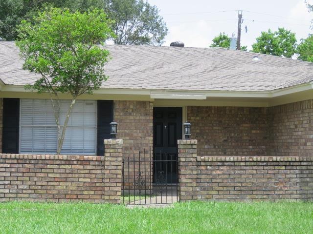 800 Cactus St, Bridge City, TX 77611 - doorway to property with brick siding and roof with shingles