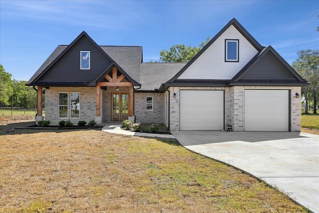 view of front of property featuring a front yard, french doors, concrete driveway, brick siding, and a shingled roof