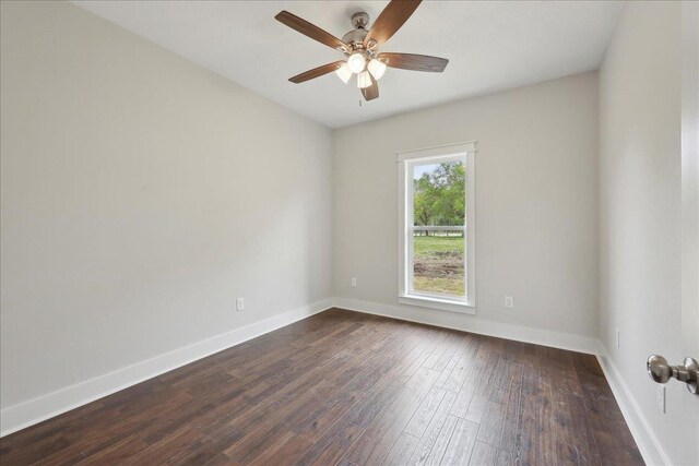 empty room featuring baseboards, dark wood-style flooring, and a ceiling fan