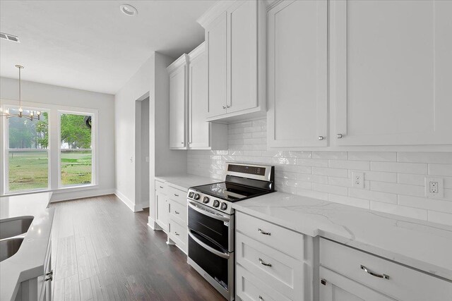 kitchen featuring white cabinetry, double oven range, backsplash, light stone counters, and a notable chandelier