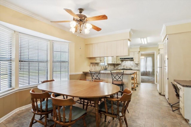 dining space with ceiling fan, sink, and ornamental molding