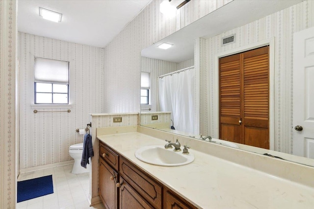 bathroom with tile patterned flooring, vanity, and toilet