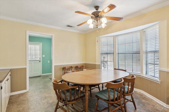 dining space with ceiling fan and ornamental molding