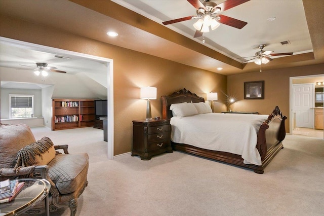 bedroom with ceiling fan, light colored carpet, and a tray ceiling