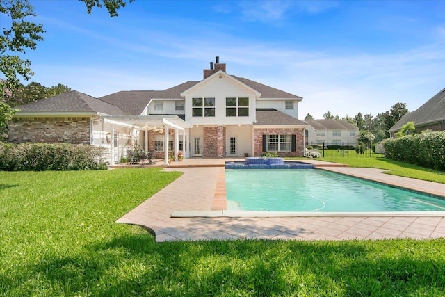 back of property featuring a swimming pool with hot tub, a yard, a pergola, and a patio area