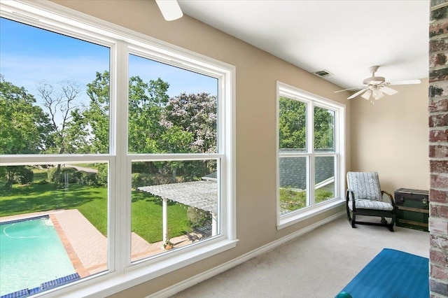 sunroom / solarium featuring a wealth of natural light and ceiling fan