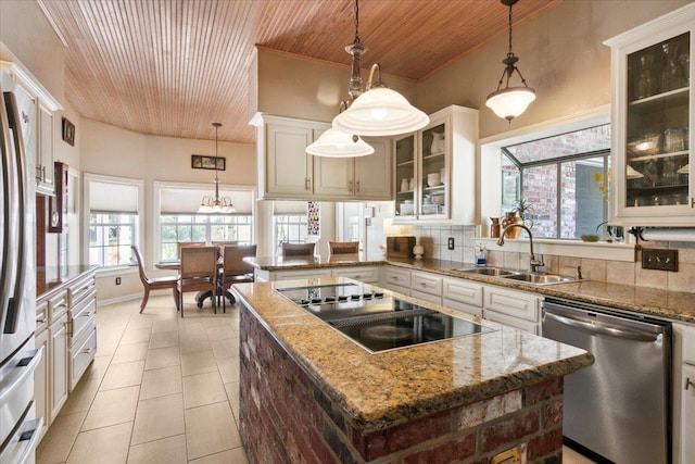 kitchen with stainless steel appliances, a center island, sink, and decorative light fixtures