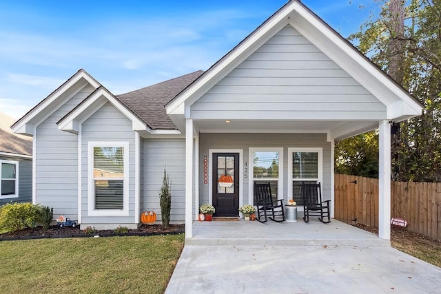 view of front of house with covered porch and a front yard