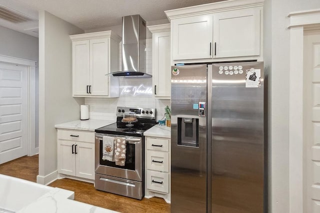 kitchen featuring white cabinets, wall chimney exhaust hood, dark hardwood / wood-style floors, and appliances with stainless steel finishes