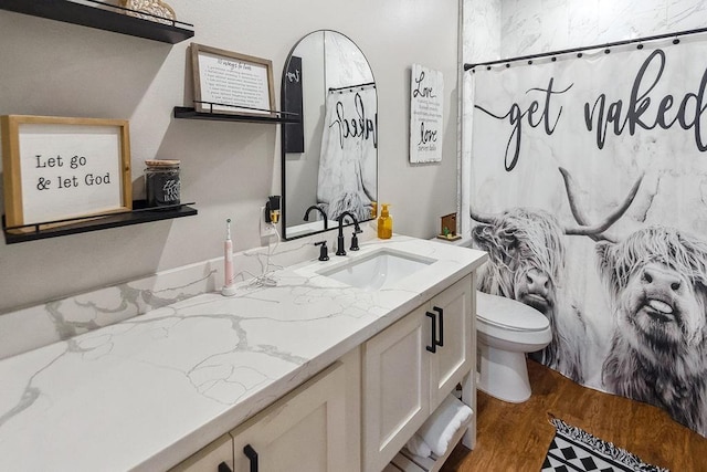 bathroom with hardwood / wood-style floors, vanity, a shower with shower curtain, and toilet