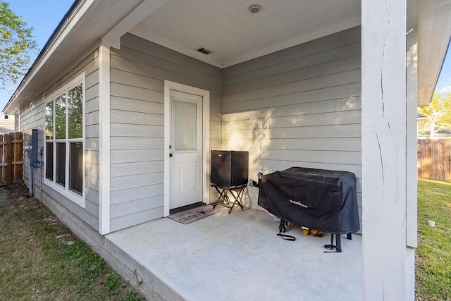 view of exterior entry with a patio area