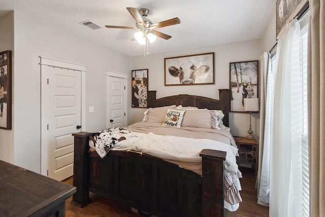 bedroom featuring ceiling fan, dark hardwood / wood-style flooring, and a textured ceiling