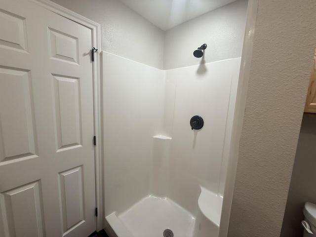390 W Park St, Vidor, TX 77662 - bathroom featuring a textured wall, a stall shower, and toilet