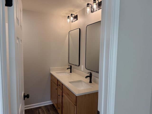 390 W Park St, Vidor, TX 77662 - bathroom featuring double vanity, wood finished floors, and baseboards