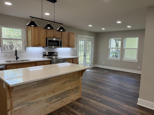 390 W Park St, Vidor, TX 77662 - kitchen featuring stainless steel appliances, a sink, baseboards, brown cabinetry, and recessed lighting