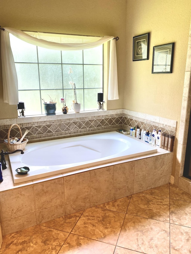 bathroom with tile patterned flooring, tiled bath, and plenty of natural light