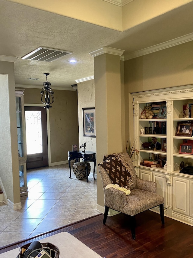 living area with light hardwood / wood-style flooring, a textured ceiling, and ornamental molding