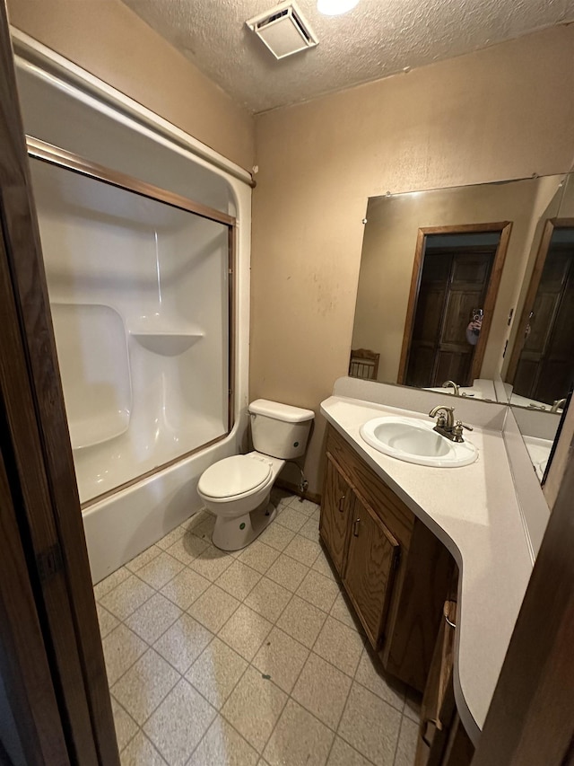 full bathroom featuring shower / washtub combination, vanity, a textured ceiling, and toilet