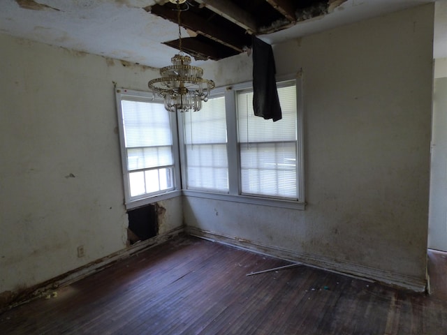 unfurnished dining area featuring dark hardwood / wood-style flooring and a chandelier