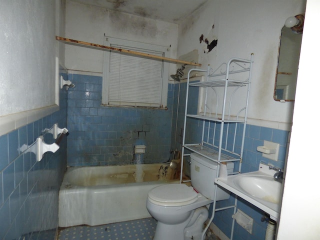 full bathroom with sink, toilet, tile walls, and tiled shower / bath