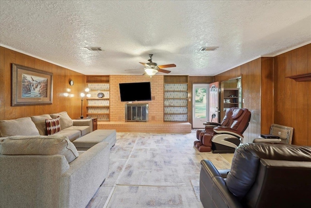 7760 Laurie Ln, Lumberton, TX 77657 - living room with wooden walls, ceiling fan, a textured ceiling, ornamental molding, and a brick fireplace