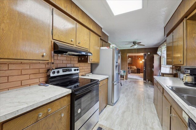 7760 Laurie Ln, Lumberton, TX 77657 - kitchen featuring stainless steel appliances, under cabinet range hood, light wood-type flooring, light countertops, and ceiling fan