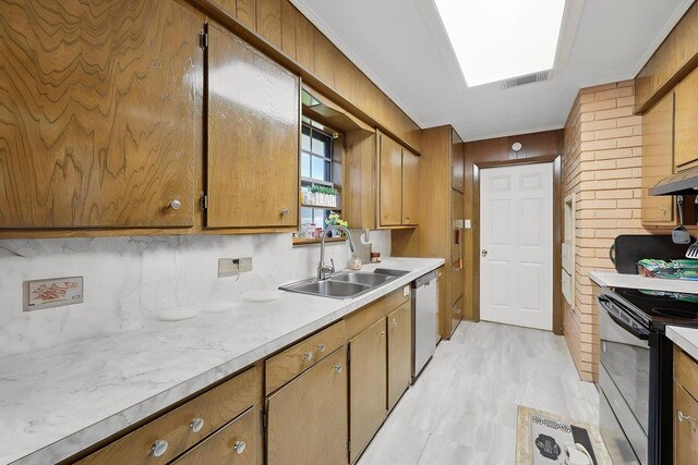 7760 Laurie Ln, Lumberton, TX 77657 - kitchen featuring a sink, black range with electric cooktop, dishwasher, light countertops, and wooden walls
