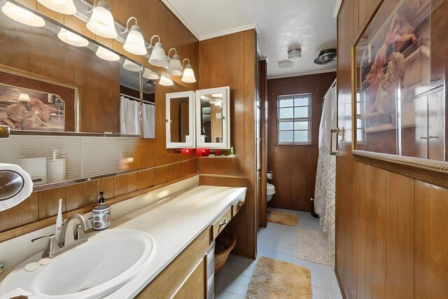 7760 Laurie Ln, Lumberton, TX 77657 - full bath with tile patterned flooring, toilet, wooden walls, vanity, and a textured ceiling