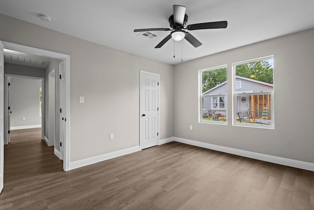 unfurnished bedroom featuring wood finished floors, baseboards, and a ceiling fan