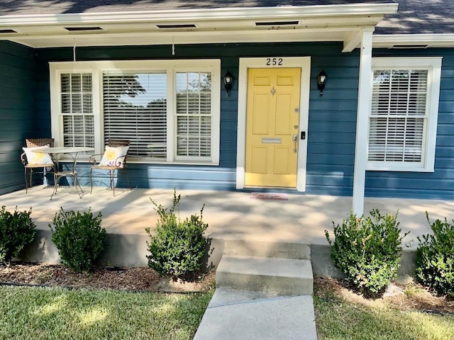 view of exterior entry featuring covered porch