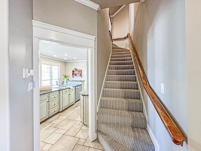 stairway with tile patterned flooring, sink, and crown molding