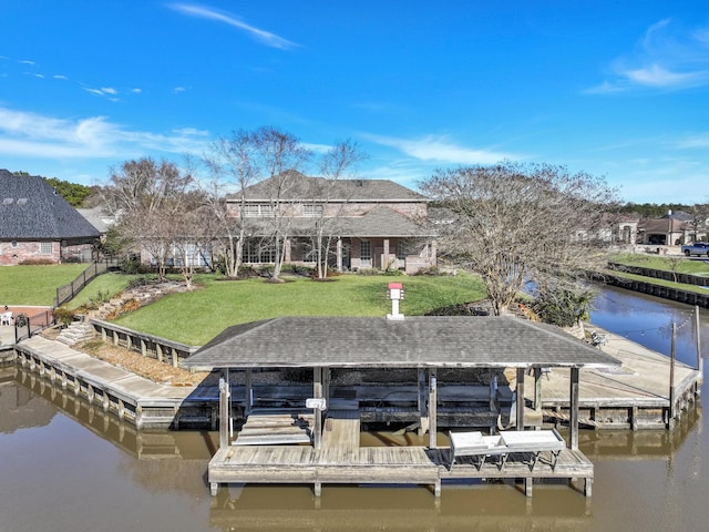 dock area with a water view and a yard