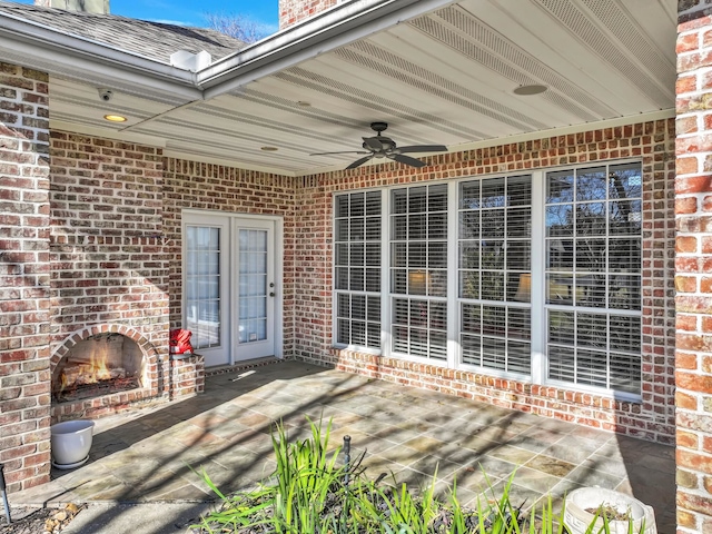 view of patio / terrace featuring an outdoor brick fireplace and ceiling fan