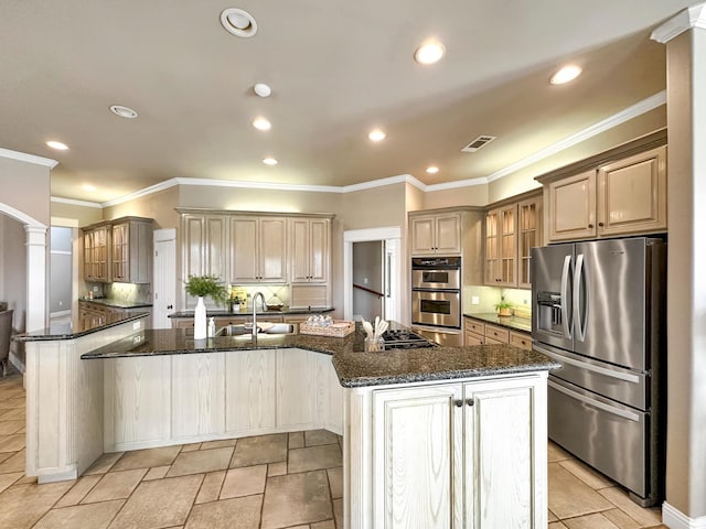 kitchen featuring sink, appliances with stainless steel finishes, a kitchen island with sink, backsplash, and dark stone countertops