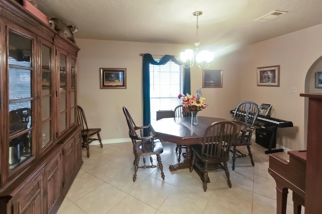 dining area featuring light tile patterned floors and an inviting chandelier