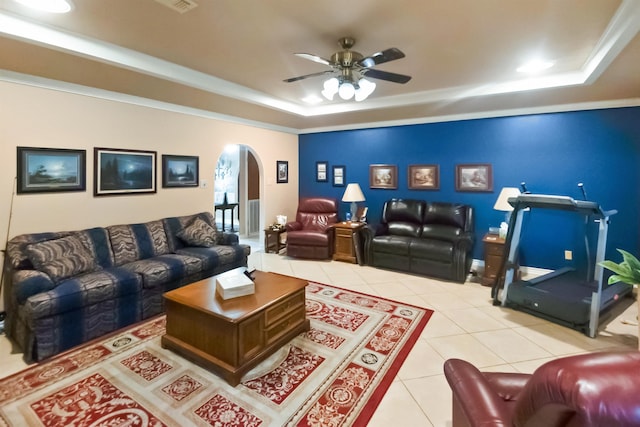 living room featuring ceiling fan, a raised ceiling, light tile patterned floors, and ornamental molding