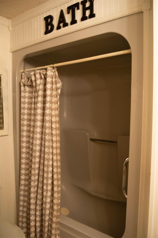 bathroom featuring a shower with curtain and a textured ceiling